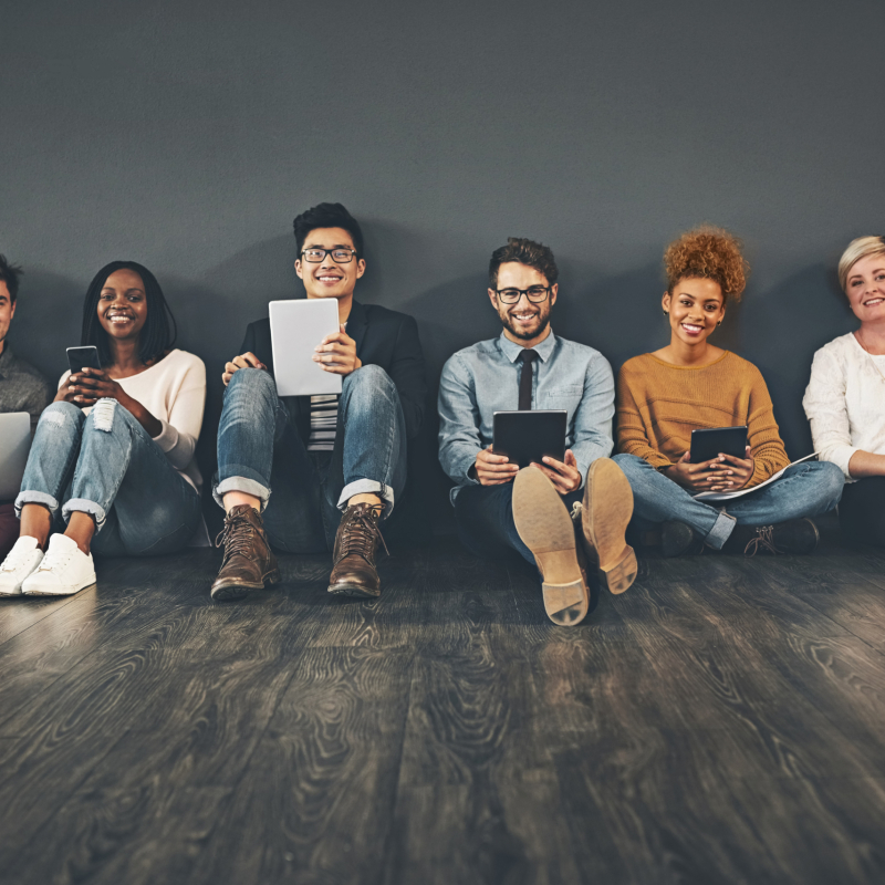 Studio shot of a diverse group of creative employees social networking against a grey background